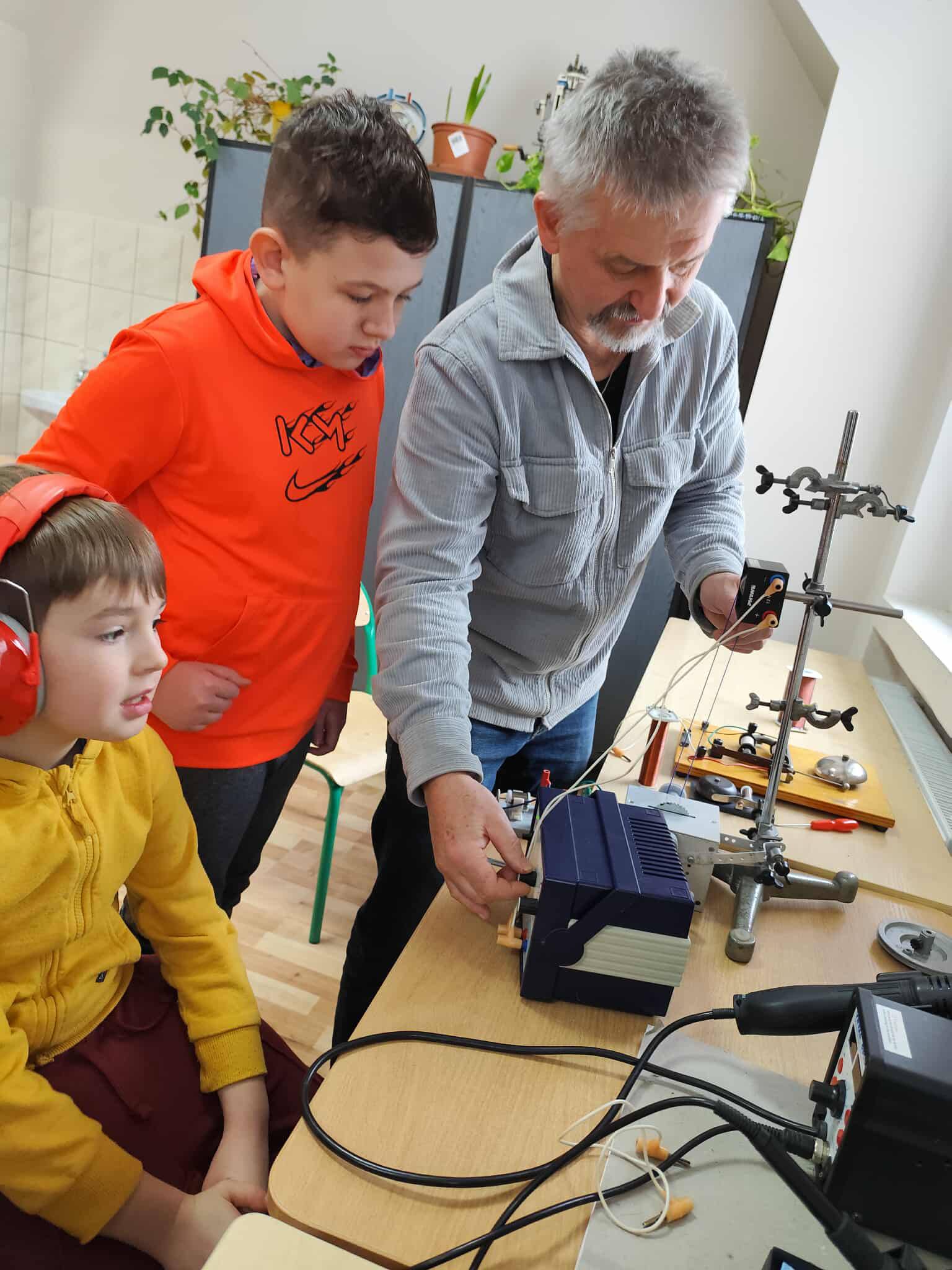 W pomieszczeniu znajdują się trzy osoby, sprzęt techniczny