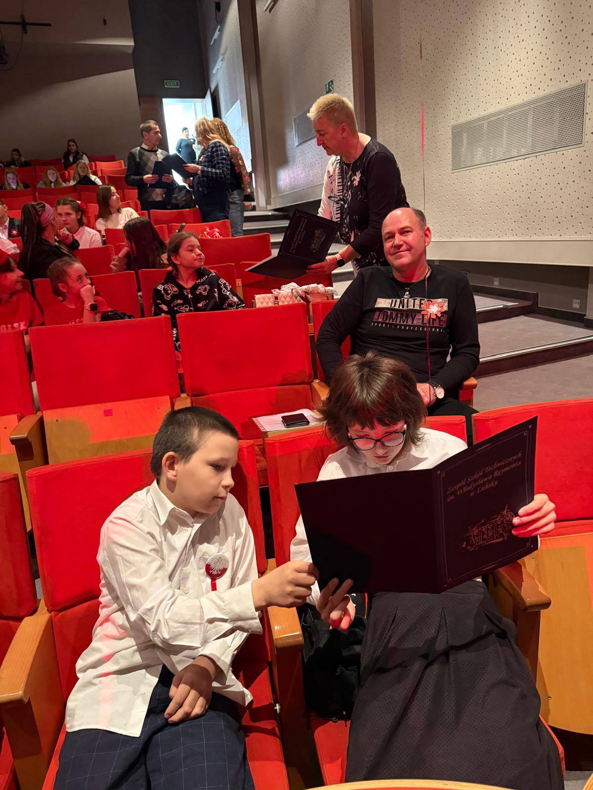 Na obrazku widać: grupę osób