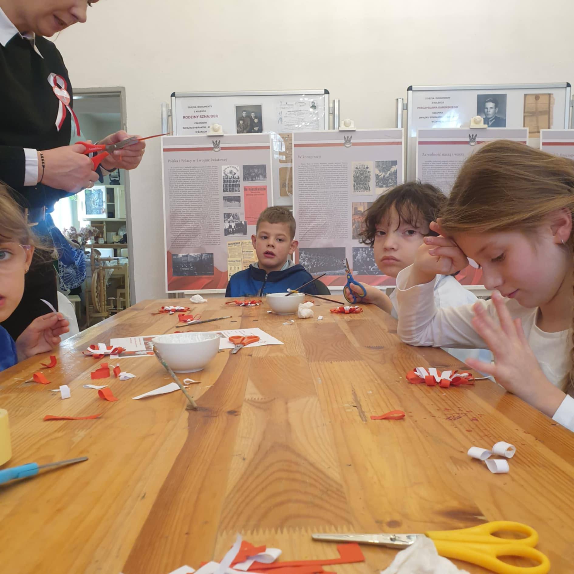 Na obrazku widać: grupę osób, blat stołu, 