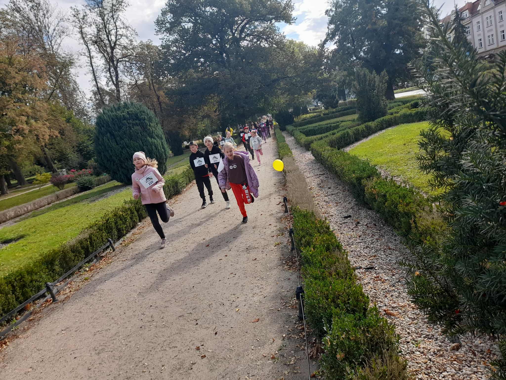 Na obrazku widać: grupę osób, park