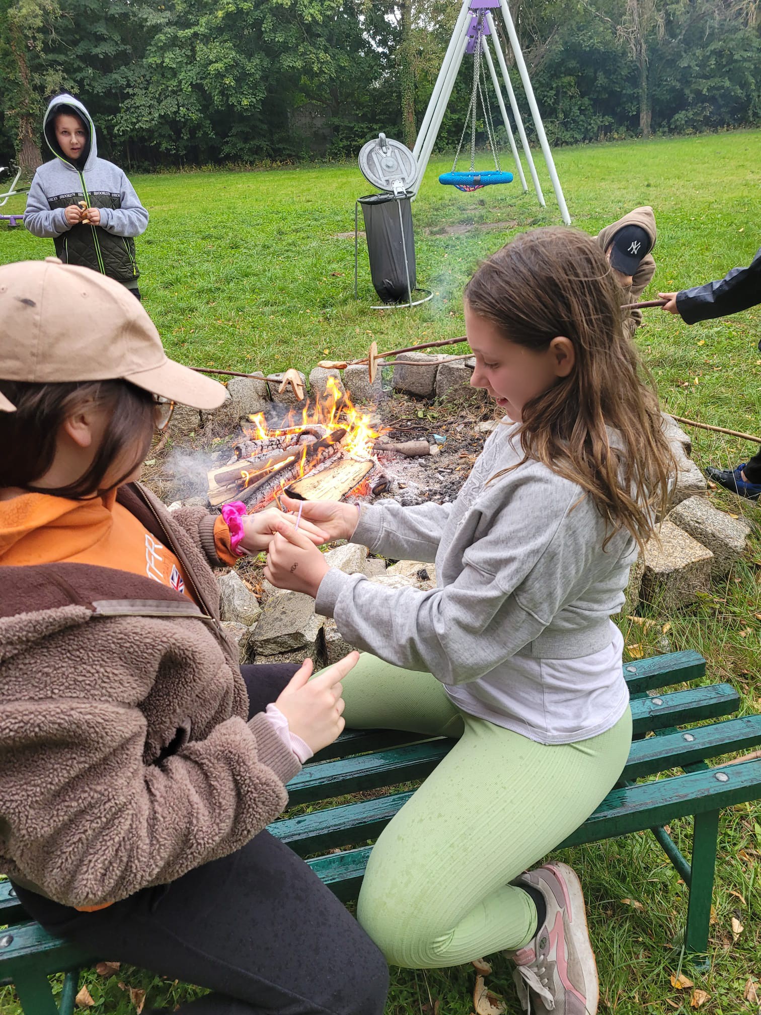 Na obrazku widać grupę osób, ognisko 