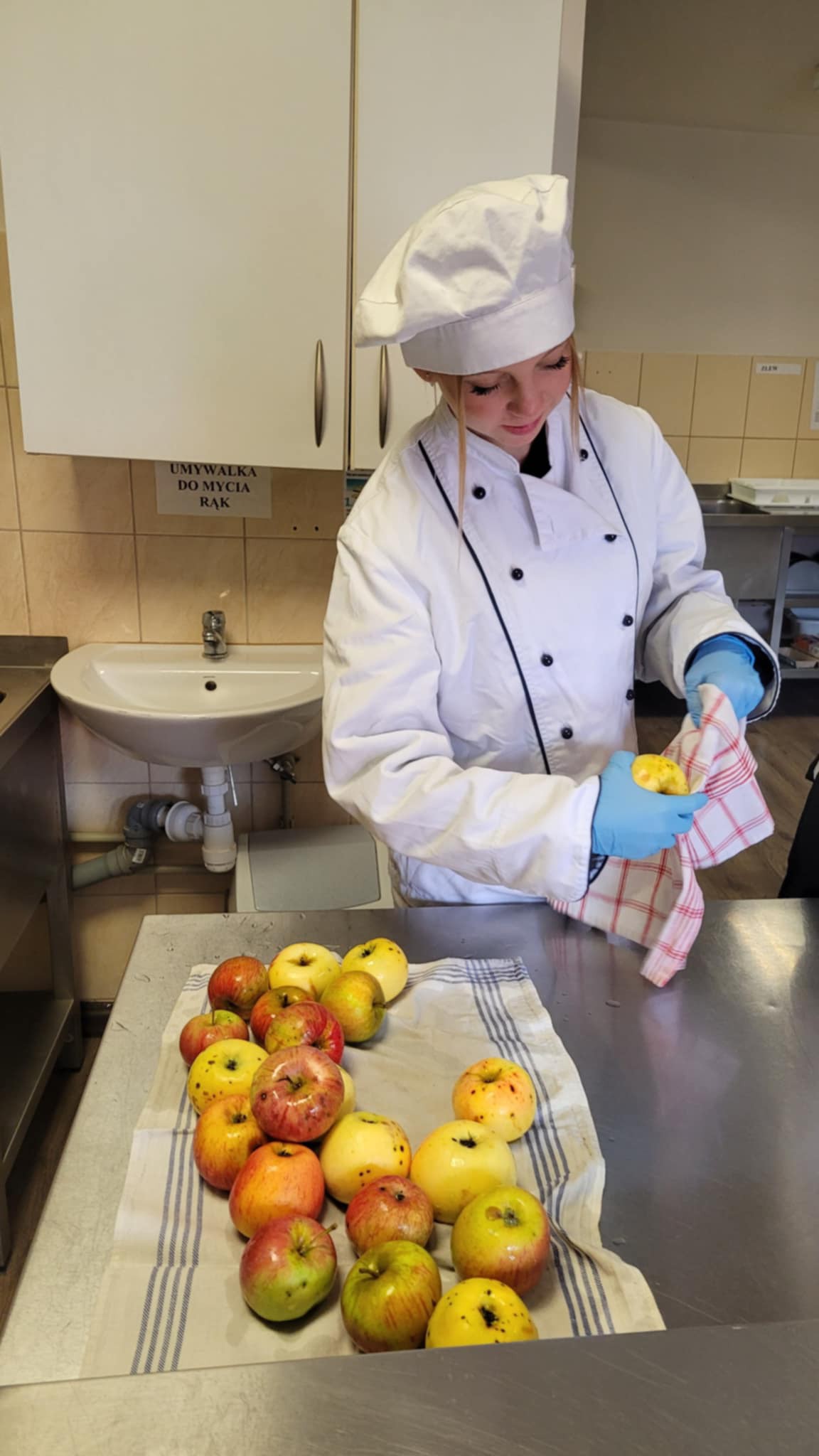 Na obrazku widać: osobę , jabłka na stole