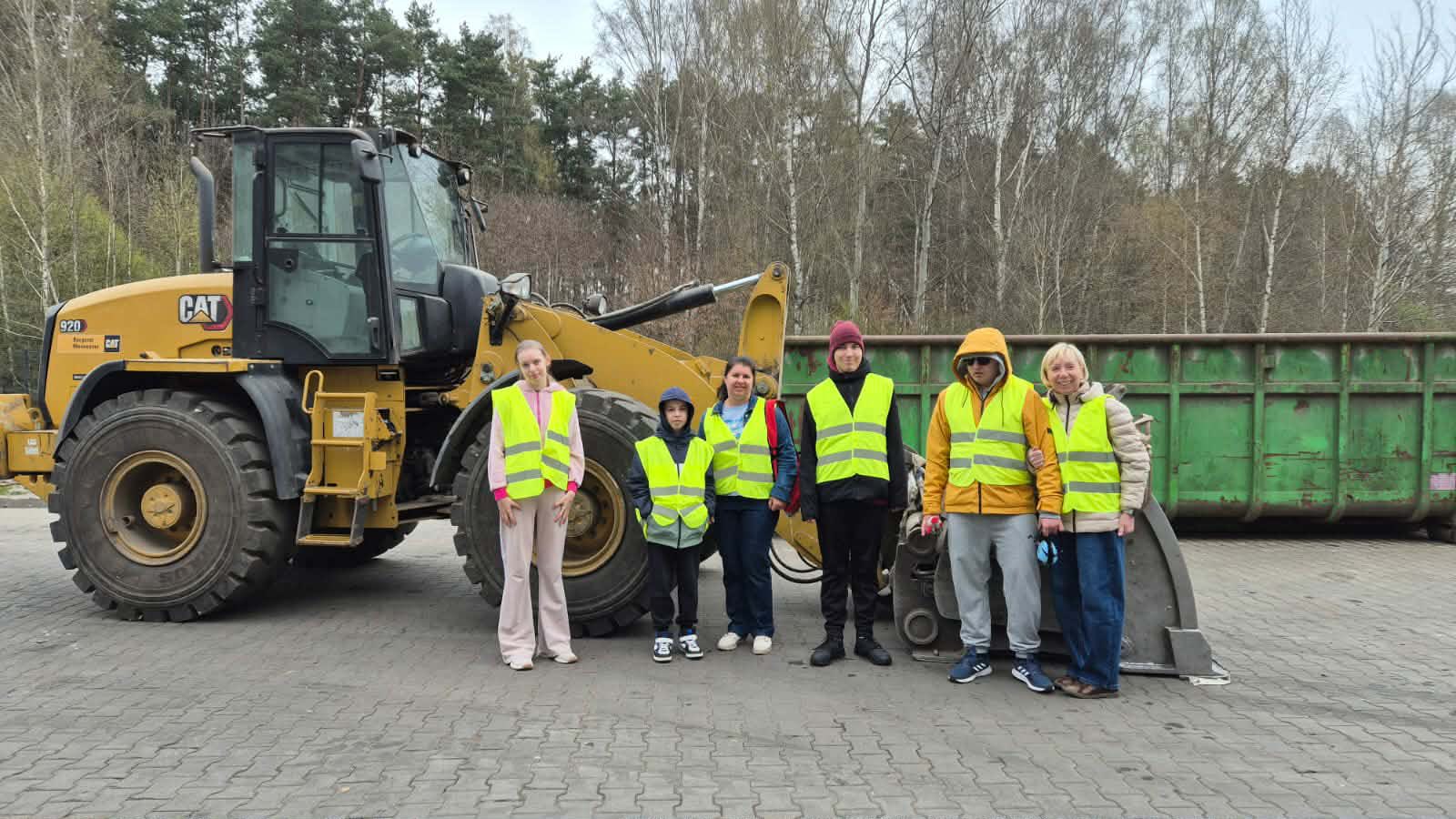 Na obrazku widać: traktor, grupę osob