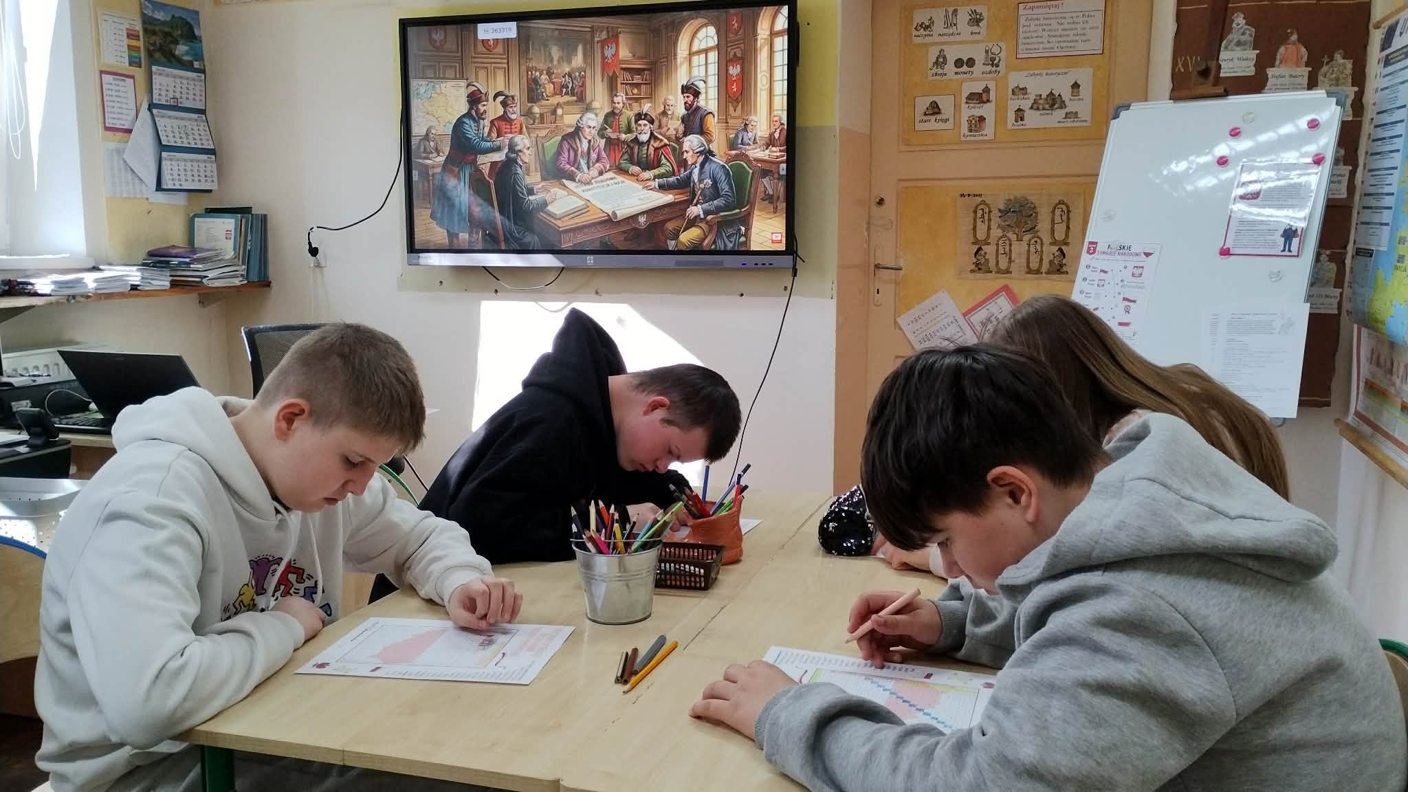Na obrazku widać : osoby, stolik, ekran