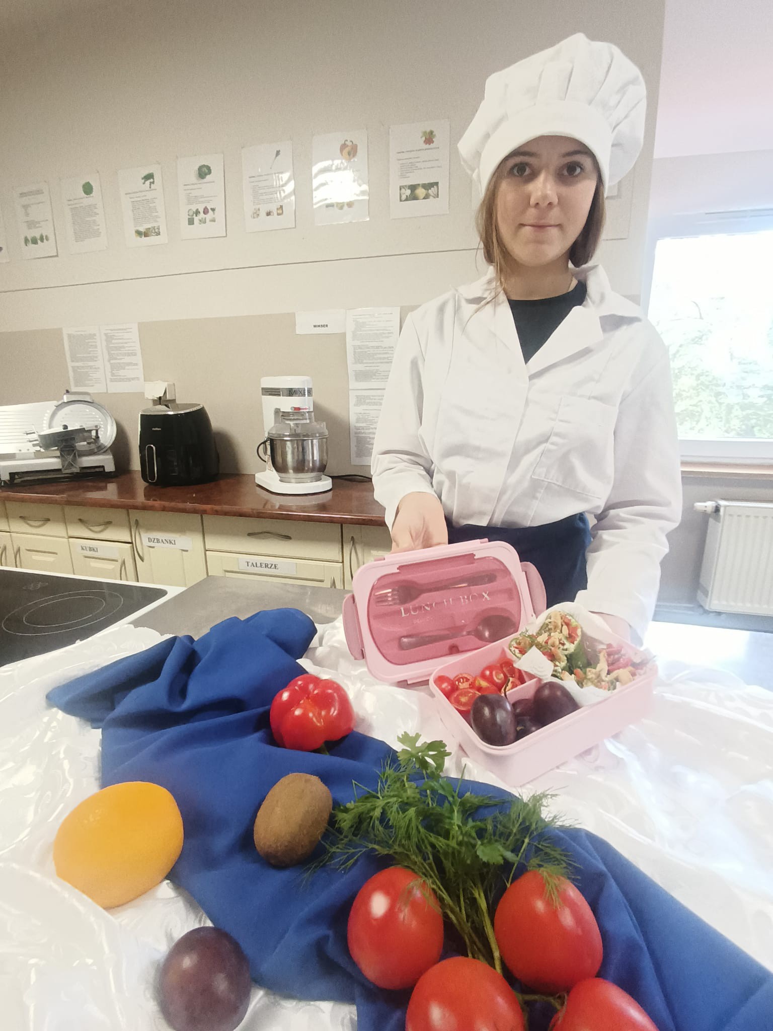 Na obrazku widać: osobę , pojemnik, potrawy, owoce i warzywa 